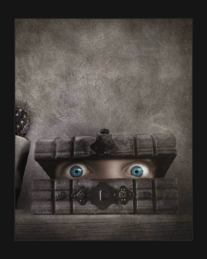 fine art photography - A pair of eyes peak out of a wooden box in this dark and surreal painterly art. This creepy art image is made up from an oversized face - too large from the box it is emerging from.